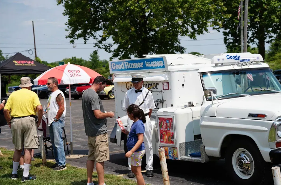 Members and families of all ages gathered around an ice cream truck at a Post 4093 community event