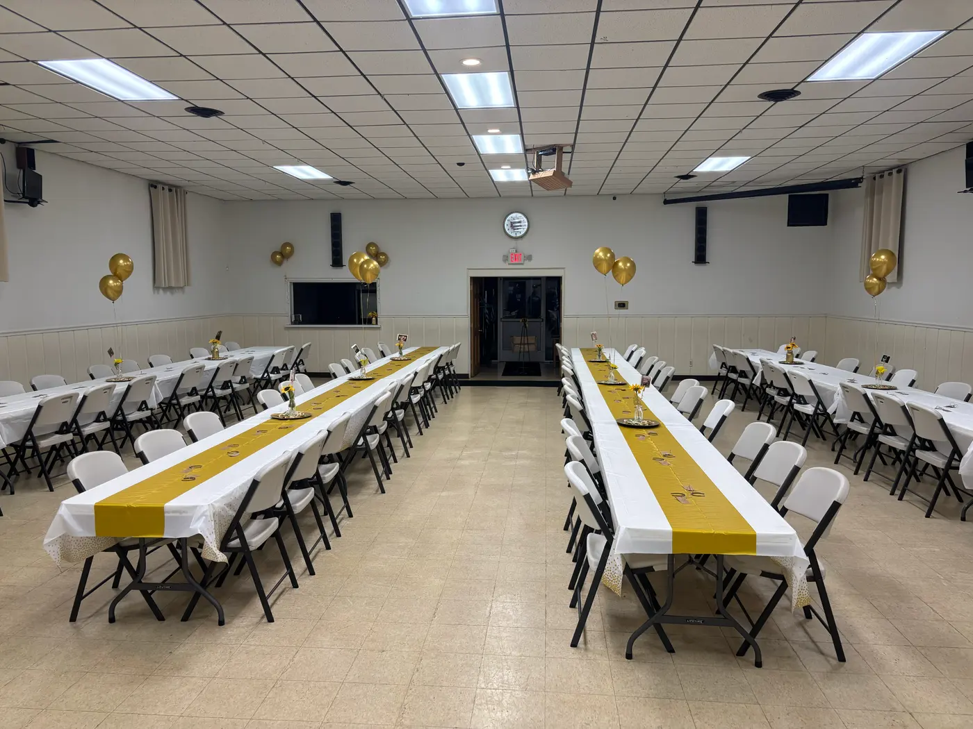 The Post 4093 Hall set up for an event, with long tables, chairs, and gold table runners